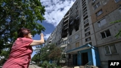 A local resident looks at a damaged residential building in Saltivka, a northern district of the second-largest Ukrainian city of Kharkiv on July 31, 2022, amid the Russian invasion of Ukraine. 