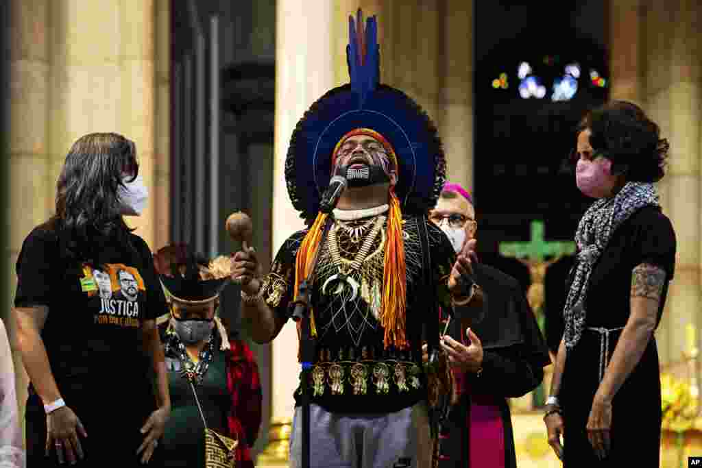 Indigenous leader Maximo Wassu says a prayer accompanied by Beatriz Matos, left, the wife of the late Indigenous expert Bruno Pereira, and Alessandra Sampaio, right, the widow of British journalist Dom Phillips, during a service in honor of Phillips and Pereira who were killed in the Amazon region, at the Cathedral in Sao Paulo, Brazil, July 16, 2022.