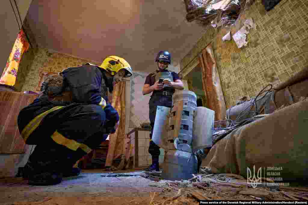 Ukraine&#39;s State Emergency Service members inspect an unexploded shell from a Smerch multiple launch rocket system inside a residential apartment in Kramatorsk&nbsp;as Russia&#39;s attack on Ukraine continues.