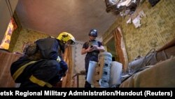 Ukraine&#39;s State Emergency Service members inspect an unexploded shell from a Smerch multiple launch rocket system inside a residential apartment in Kramatorsk&nbsp;as Russia&#39;s attack on Ukraine continues.