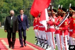 Presiden Timor Leste Jose Ramos Horta (kiri), didampingi Presiden Indonesia Joko Widodo memeriksa pasukan kehormatan setibanya di Istana Kepresidenan di Bogor, Jawa Barat, Selasa, 19 Juli 2022. (Adi Weda/ Pool Photo via AP)