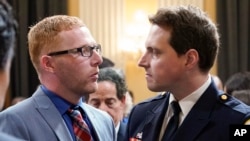 Stephen Ayres, left, who pleaded guilty last in June 2022 to disorderly and disruptive conduct in a restricted building, speaks with Washington Metropolitan Police Department officer Daniel Hodges as the hearing with House select committee investigating the January 6 attack on the Capitol ends in Washington, July 12, 2022.