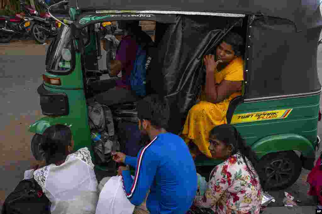 Una joven sentada en un vehículo espera junto con otros en la cola para obtener sus pasaportes fuera del Departamento de Inmigración y Emigración en Colombo, Sri Lanka.
