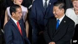 FILE - Indonesia's President Joko Widodo, left, speaks to China's President Xi Jinping at the G-20 summit, on June 28, 2019, in Osaka, Japan. Widodo was heading to Beijing on July 25, 2022, for a rare visit by a foreign leader under China's strict COVID-19 protocols.