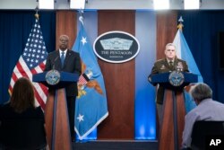 Secretary of Defense Lloyd Austin, left, and Joint Chiefs Chairman Gen. Mark Milley speak during a media briefing at the Pentagon, July 20, 2022, in Washington. American defense leaders said they see the war to block Russian gains in the eastern Donbas re