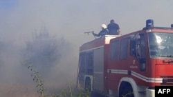 17일 우크라이나 남부 므콜라이우 시내 미사일 공격 직후 소방대원들이 밀밭에서 번지는 화재를 진압하고 있다. 