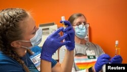 FILE: Dr. Emily Drwiega from the University of Illinois Health and Maggie Butler, a registered nurse, prepare monkeypox vaccines at the Test Positive Aware Network nonprofit clinic in Chicago, Illinois, U.S., Taken 7.25.2022