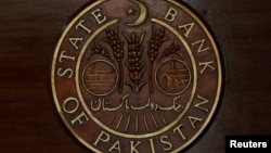 FILE - The logo of the State Bank of Pakistan (SBP) is pictured on a reception desk at the head office in Karachi, Pakistan, July 16, 2019.