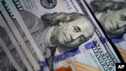 FILE - The likeness of Benjamin Franklin is seen on U.S. $100 bills, in Marple Township, Pennsylvania, July 14, 2022.