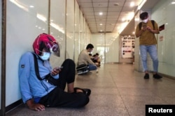 People wait indoors during the air-raid exercise named Wan An, an annual drill during which all vehicles are ordered to move to the sides of roads and pedestrians to wait in back streets in Taipei, Tai