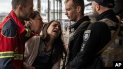 Sabina, centro, llora después de que su esposo Artem Pogorelets muriera por un bombardeo ruso en el mercado de Barabashovo en Kharkiv, Ucrania, el jueves 21 de julio de 2022. (Foto AP/Evgeniy Maloletka)