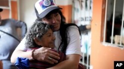 María Eva Noble, que forma parte del movimiento social "Movimiento Evita" (con una gorra), abraza a otra voluntaria en un comedor benéfico en Buenos Aires, Argentina, el 26 de julio de 2022, el día del 70mo aniversario de la muerte de la primera dama más famosa de Argentina, Eva Perón, que falleció a causa de un cáncer el 26 de julio de 1952, a los 33 años. (AP Foto/Natacha Pisarenko)