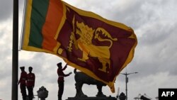 সামরিক কর্মীরা কলম্বোর গল ফেস গ্রিন-এ শ্রীলঙ্কার জাতীয় পতাকা নামাচ্ছেন। ২৩ জুলাই, ২০২২।