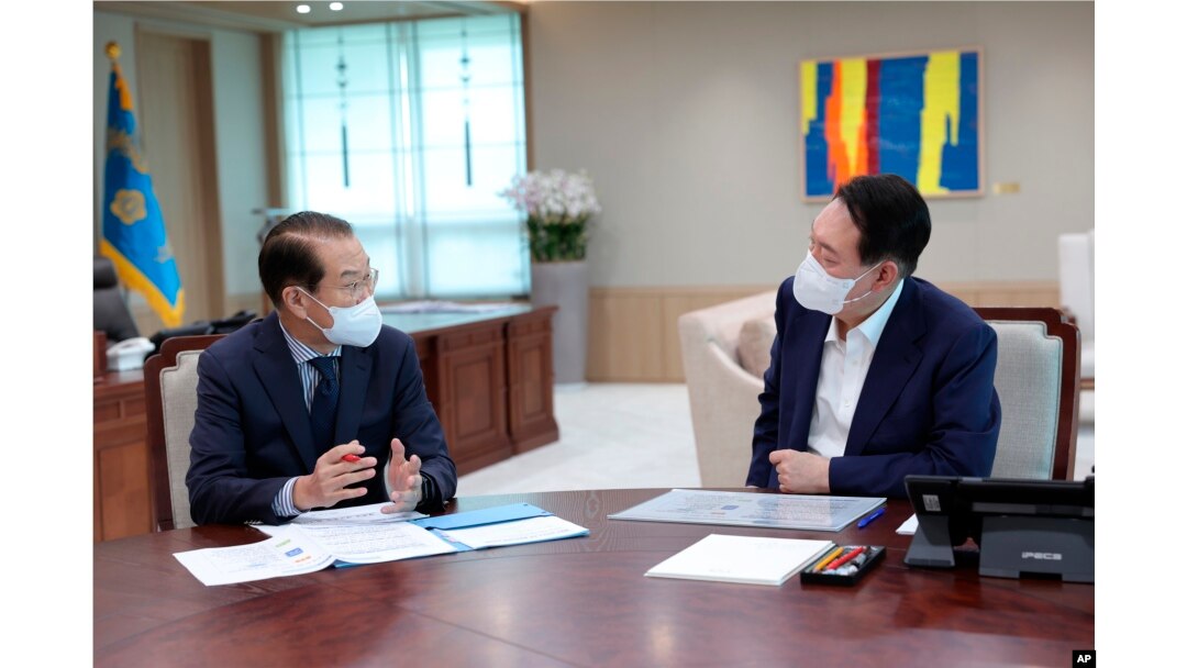 Presiden Korea Selatan Yoon Suk Yeol, kanan, mendengarkan pengarahan kebijakan Kementerian Unifikasi oleh Menteri Unifikasi Kwon Youngse di kantor kepresidenan di Seoul, Korea Selatan, 22 Juli 2022. (Foto: via AP)