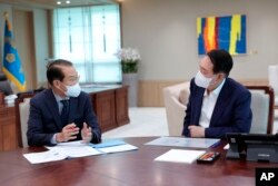 Presiden Korea Selatan Yoon Suk Yeol, kanan, mendengarkan pengarahan kebijakan Kementerian Unifikasi oleh Menteri Unifikasi Kwon Youngse di kantor kepresidenan di Seoul, Korea Selatan, 22 Juli 2022. (Foto: via AP)