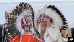 Paus Fransiskus mengenakan penutup kepala suku pribumi Kanada selama pertemuan untuk minta maaf atas penganiayaan dan pelecehan warga pribumi oleh Gereja Katolik, di kota Maskwacis, dekat Edmonton, Kanada (25/7). (Foto: AP) 