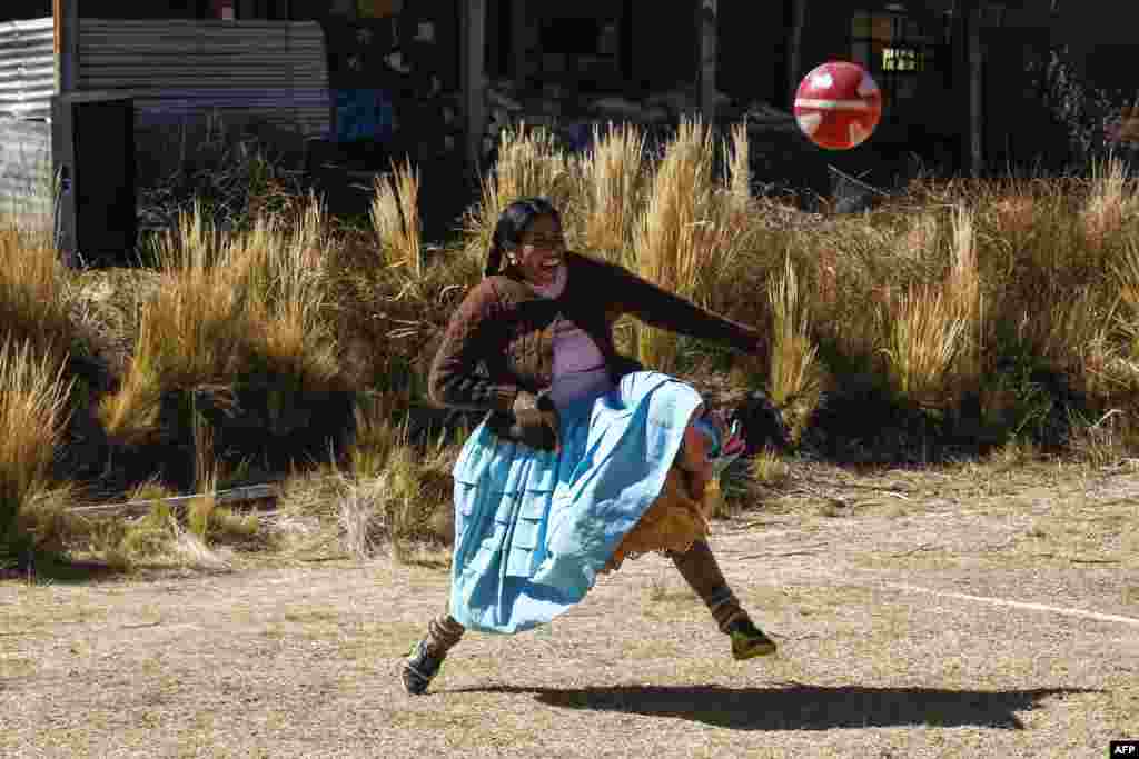 An Aymara indigenous woman plays football during a championship in the Aymara district of Juli in Puno, southern Peru, July 16, 2022.