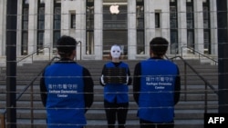 FILE - Activists set up a mock Uyghur forced labor camp outside the Apple flagship store in Washington, D.C., March 4, 2022. Demonstrators called on tech giant Apple to stop using Uyghur forced labor.