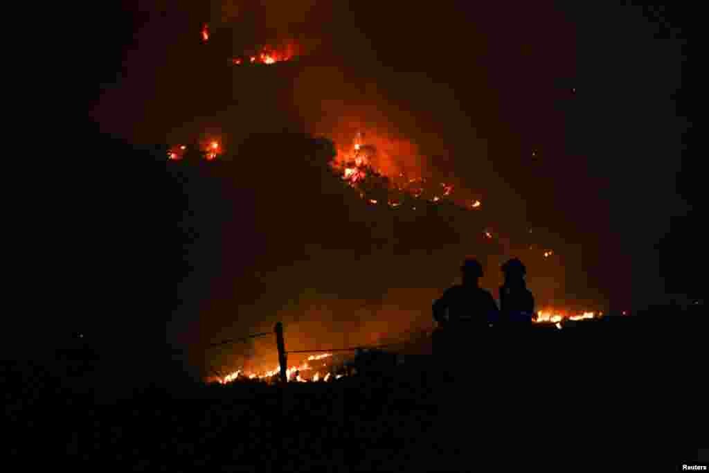 Firefighters patrol a burned area from a wildfire in Venda do Pinheiro in Mafra, Portugal, July 31, 2022. 