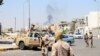 Members of the Libyan armed unit, 444 Brigade, backing the Government of National Unity (GNU) and its Prime Minister Abdulhamid al-Dbeibah, set up a checkpoint as smoke rises in the background in Ain Zara area in Tripoli, Libya, July 22, 2022. 