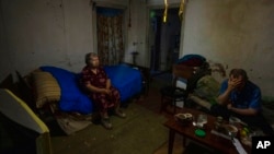 FILE - Tamara Markova, 82, and her son, who both returned to their home after fleeing, sit in their home in Malotaranivka village, in Kramatorsk, eastern Ukraine, July 18, 2022.