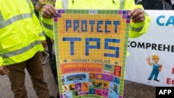 FILE - Demonstrators participate in the March for TPS (Temporary Protected Status) Justice in support of permanent residency, outside the White House, in Washington, Feb. 12, 2019. 