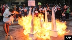 FILE - A model of the Democracy Monument built by activists is lit on fire outside the Constitutional Court of Thailand in Bangkok on November 10, 2021.