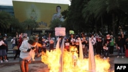 FILE - A model of the Democracy Monument built by activists is lit on fire outside the Constitutional Court of Thailand in Bangkok on November 10, 2021.