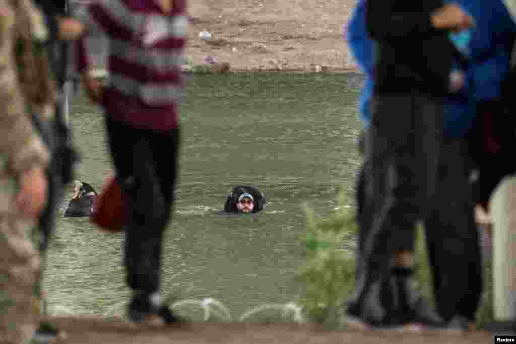 Migrantes que esperan entrar y conseguir asilo en Estados Unidos cruzan el río Grande, entre México y Estados Unidos.