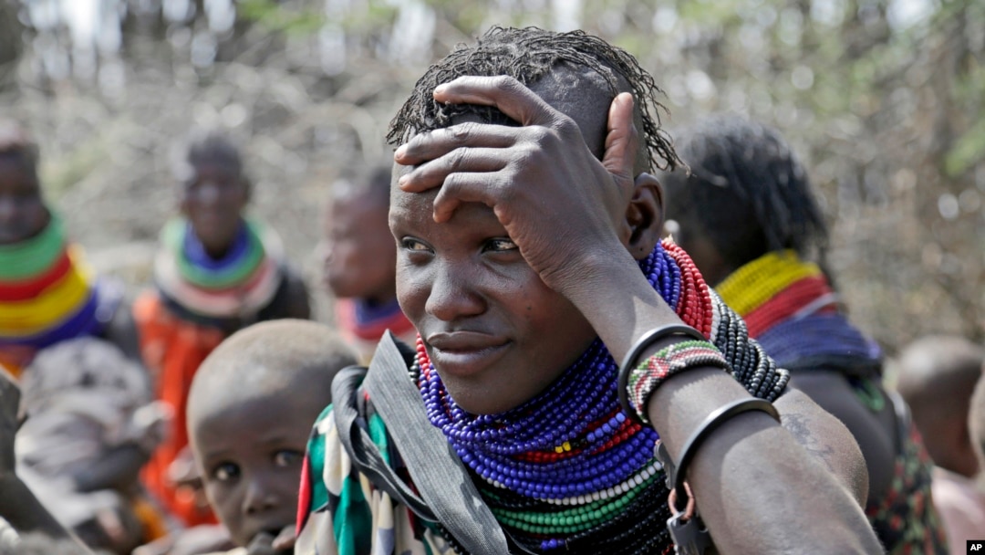 FILE - A woman waits for food distributed by the United States Agency for International Development in Kenya, July 23, 2022. Climate change and a growing world population may threaten global food security. Changes in agriculture, especially in Africa, may be the only way forward.