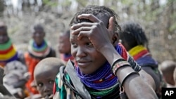 FILE - A woman waits for food distributed by the United States Agency for International Development in Kenya, July 23, 2022. Climate change and a growing world population may threaten global food security. Changes in agriculture, especially in Africa, may be the only way forward.