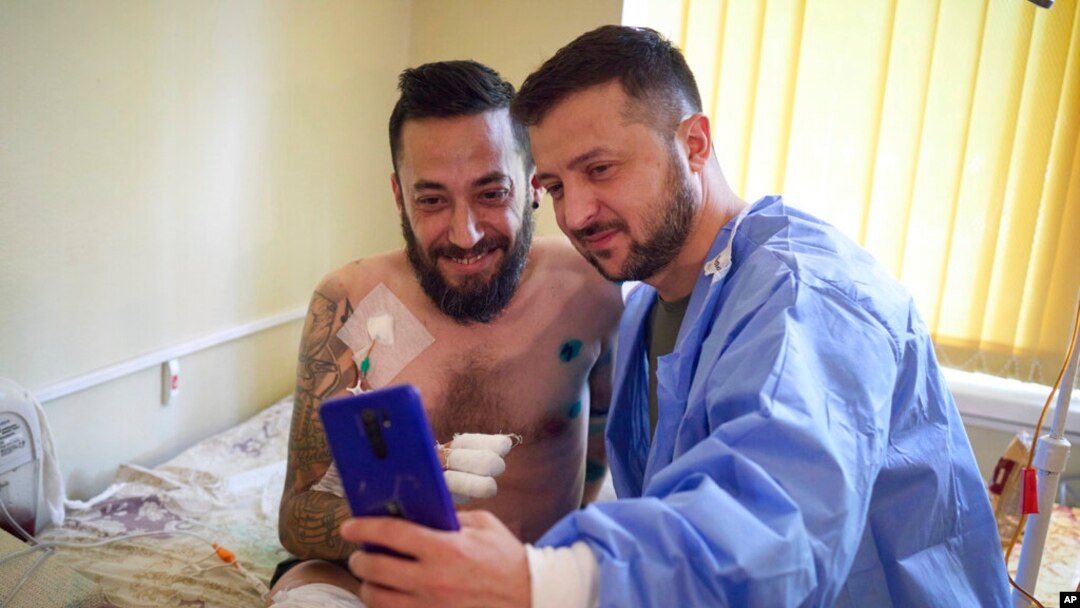 En esta imagen, distribuida por la oficina de prensa de las presidencia de Ucrania, el presidente del país, Volodymyr Zelenskyy (derecha), se toma una selfie con un soldado herido, en un hospital en Odesa, el 29 de julio de 2022.