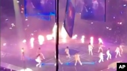 In this image made from video taken from social media, a massive video screen falls on performers at a concert of boy band Mirror, in Hong Kong, July 28, 2022. 