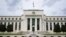 FILE - An American flag flies over the Federal Reserve building in Washington, May 4, 2021.