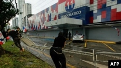 Protesters tear down a barrier at the headquarters of the Partido Revolucionario Democratico during a protest against the high cost of food and gasoline in Panama City, July 20, 2022.