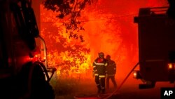 Esta foto proporcionada por el cuerpo de bomberos de la región de Gironde (SDIS 33) muestra a los bomberos luchando contra un incendio forestal cerca de Landiras, suroeste de Francia, el domingo 17 de julio de 2022.