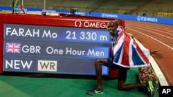 FILE - Britain's Mo Farah poses next to the board after setting a world record during the One Hour Men at the Diamond League Memorial Van Damme athletics event at the King Baudouin stadium in Brussels on Sept. 4, 2020.
