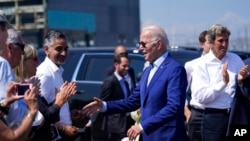 President Joe Biden greets people after speaking about climate change and clean energy at Brayton Power Station, July 20, 2022, in Somerset, Mass. Special Presidential Envoy for Climate John Kerry is at right.