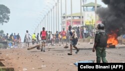 FILE: A police officer looks on as protesters block roads and hurl rocks in Conakry on 7.28.2022, after authorities prevented supporters of the opposition party, National Front for the Defense of the Constitution (FNDC), from gathering in the streets for a peaceful march.