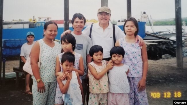 Ông Nam Lộc và một gia đình di dân người Việt. Ảnh do ông Nam Lộc cung cấp.