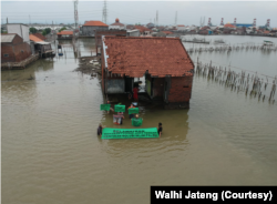 Aktivis lingkungan menggelar aksi keprihatinan di tengah bencana rob dan tenggelamnya pesisir Jawa Tengah, Juli 2022. (Foto: Dok Walhi Jateng)