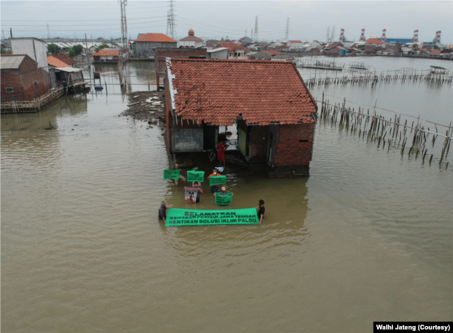 Aktivis lingkungan menggelar aksi keprihatinan di tengah bencana rob dan tenggelamnya pesisir Jawa Tengah, Juli 2022. (Foto: Dok Walhi Jateng)