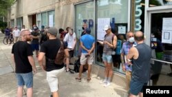 FILE: Men line up outside the Test Positive Aware Network nonprofit clinic to receive the monkeypox vaccine in Chicago, Illinois. Taken 7.25.2022