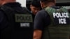 Un migrante es escoltado por agentes del Servicio de Inmigración y Control de Aduanas (ICE) de EEUU para ser llevados a México, en Laredo, Texas, el15 de junio de 2022.