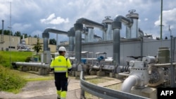 FILE - An employee of Uniper Energy Storage walks through the above-ground facilities of a natural gas storage facility in Bierwang, Germany, June 10, 2022. he German state will take 30% of the capital of the energy giant Uniper, threatened with bankruptcy.