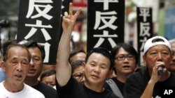 Tiananmen Square protester Xiong Yan, center, flashes a victory sign during a march in Hong Kong, May 31, 2009, marking the 20th anniversary of the military crackdown in Beijing. Xiong, who later served in the U.S. military and is now running for a seat in Congress, says the Chinese government "tried to sink my campaign."