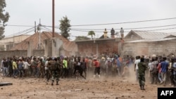 Des soldats des forces armées de la République démocratique du Congo tentent de contrôler une foule de manifestants prenant d'assaut une base de l'opération de maintien de la paix de l'ONU, la Monusco, à Goma, le 26 juillet 2022.