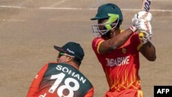 ফাইল ছবি-হারারে স্পোর্টস ক্লাবে জিম্বাবুয়ে এবং বাংলাদেশের মধ্যে প্রথম টি-টোয়েন্টি আন্তর্জাতিক ক্রিকেট ম্যাচ চলাকালীন জিম্বাবুয়ের রেজিস চাকাবভা বাংলাদেশের উইকেটরক্ষক নুরুল হাসানকে পাশ কাটিয়ে একটি শট খেলছেন।২২ জুলাই ২০২১। (ছবি-এএফপি/জেকেসাই জিকিজানা)