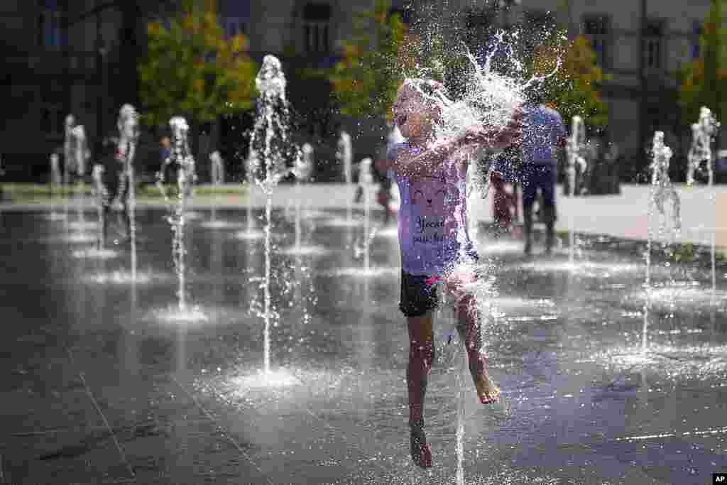 A girl cools off in a public fountain in Vilnius, Lithuania.