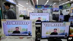 Sebuah toko elektronik di Seoul, Korea Selatan, menampilkan program berita yang menunjukkan surat kabar Korea Utara dengan foto pemimpin Korea Utara Kim Jong Un sedang tersenyum, 14 Oktober 2014. (AP /Ahn Young-joon, File)